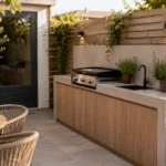 Compacte buitenkeuken in een kleine tuin met barbecue, smal werkblad en praktische opbergruimte
